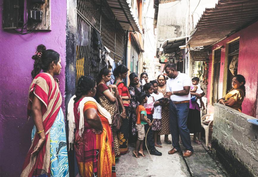 Seorang anggota staf World Mosquito Program bersama anggota komunitas di Sri Lanka