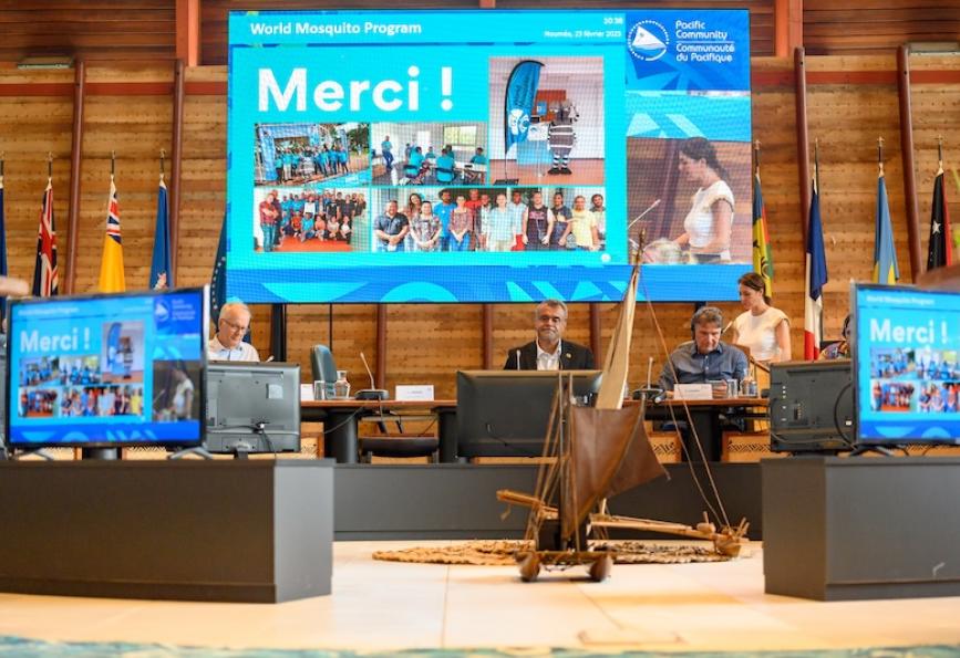 Foto layar proyektor yang menampilkan ucapan 'merci' sebagai bentuk apresiasi atas keberhasilan implementasi Wolbachia oleh World Mosquito Program di Kaledonia Baru