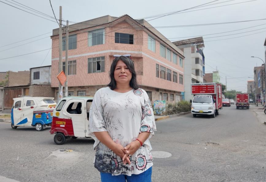 Alicia, seorang relawan komunitas, sedang berdiri di jalan di Comas, Peru