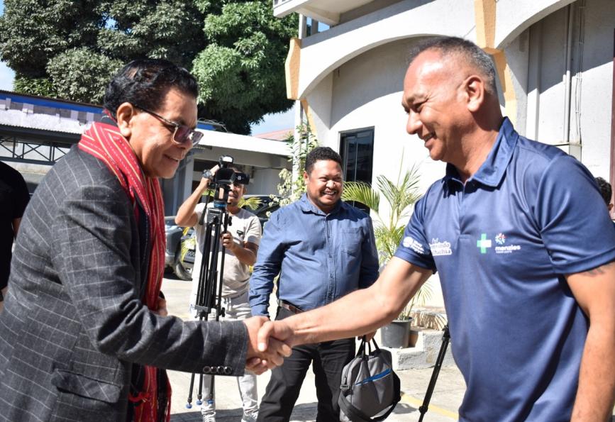 Menteri Kesehatan Timor-Leste sedang bertemu dengan seorang relawan dari World Mosquito Program . Kamera terlihat di latar belakang. 